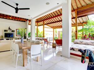 a dining room and living room with a bed and a table at Villa Shanti in Seminyak