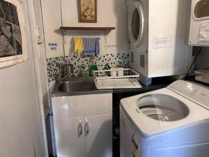 a small kitchen with a sink and a washing machine at Palm Heights in Palm Beach