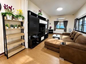 a living room with a couch and a large television at Pool Smile Villa in Bangsaen