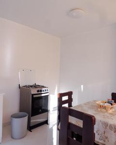 a kitchen with a stove and a table with a tableablish at Alojamiento Primer Piso Confort Riobamba in Riobamba