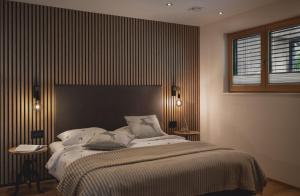 a bedroom with a large bed with a black headboard at Lieblingsplatz Alpine Lodge in Tschagguns