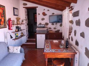 a living room with a table and a tv at Casita Bentayga in Tejeda