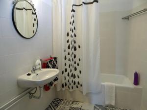 a bathroom with a sink and a shower curtain at Alegria Apartment Porto Downtown in Porto