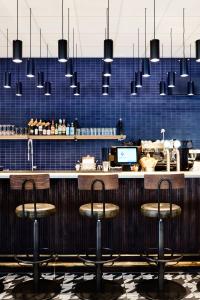 a bar with three stools in front of a counter at Generator Stockholm in Stockholm