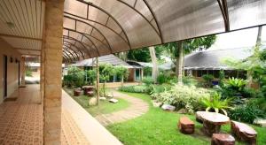a building with a courtyard with benches and plants at Banna Resort in Ban Khlong Kadon (1)