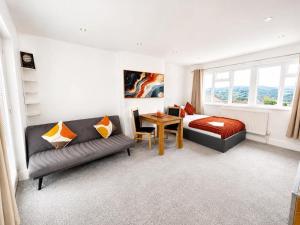 a bedroom with a couch and a bed and a table at Jolly Jupiter at The Moon in Pontnewynydd