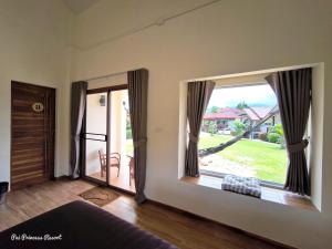 a room with a large window with a view of a yard at Pai Princess Resort in Pai