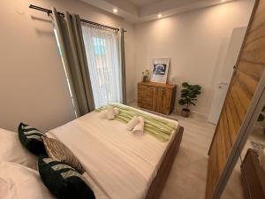 a bedroom with a bed with two towels on it at Olive Apartment Cosmopolis in Tunari +27 photos