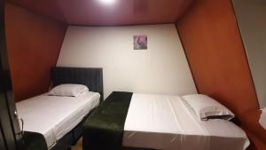 two twin beds in a small room with at Cabaña la Valkiria in Falan