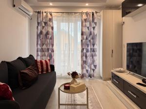 a living room with a couch and a table at Olive Apartment Cosmopolis in Tunari