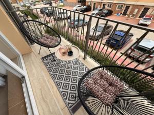 a balcony with two chairs and a view of a street at Olive Apartment Cosmopolis in Tunari
