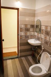 a bathroom with a toilet and a sink at Misty Leaf in Thekkady
