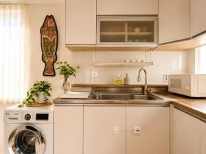 a kitchen with a sink and a washing machine at TOV stay in Seoul