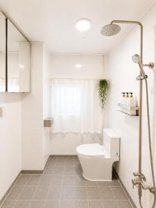 a white bathroom with a toilet and a shower at TOV stay in Seoul +29 photos