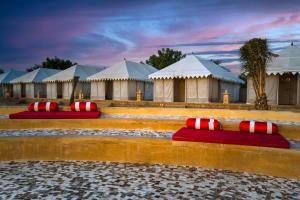 a row of white tents with red and white pillows at Rojani Resort in Sām