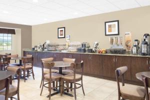 a restaurant with tables and chairs and a counter at Microtel Inn & Suites Mansfield PA in Mansfield