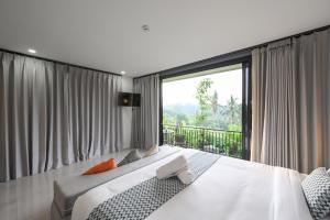 a bedroom with a bed and a large window at Root and Rise Cabins in Tabanan +38 photos