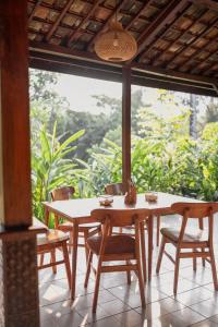 a table and chairs in front of a large window at Udaka Retreat in Payangan