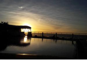a sunset over a body of water with the sun setting at Auberge Oualidia Dream in Oualidia