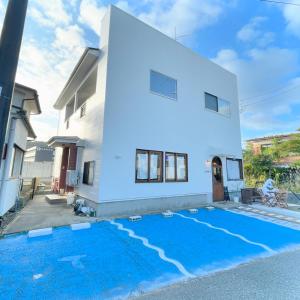 a house with a blue carpet in front of it at Bridge33 CAFE AND HOSTEL in Takagi