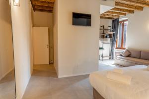 a bedroom with a couch and a tv on a wall at Montenero City Rooms in Verona +21 photos