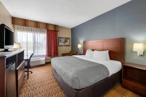 a hotel room with a large bed and a television at Quality Inn & Suites Lawrence - University Area in Lawrence +24 photos