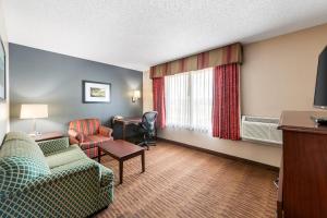 a hotel room with a couch and a chair and a desk at Quality Inn & Suites Lawrence - University Area in Lawrence