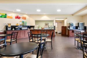 a restaurant with tables and chairs and a kitchen at Quality Inn & Suites Lawrence - University Area in Lawrence