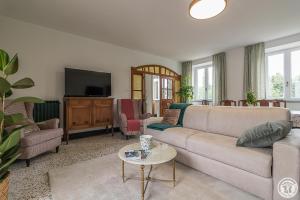 a living room with a couch and a tv at L'ecole à l'ancienne in Aulon