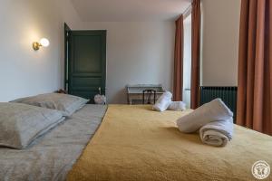 a bedroom with a large bed with towels on it at L'ecole à l'ancienne in Aulon
