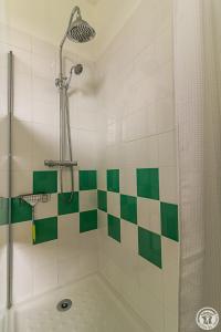 a bathroom with a shower with green and white tiles at L'ecole à l'ancienne in Aulon +39 photos