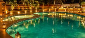a swimming pool at night with lights in it at Waves P'opin Resort in Mahabalipuram +23 photos