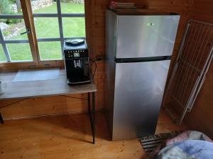 a refrigerator sitting next to a table in a room at Maalähedane elamus Saaremaal! in Oti