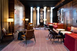 a lobby with tables and chairs and a couch at Cambria Hotel Boston Somerville in Somerville