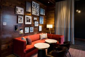 a living room with a couch and two tables at Cambria Hotel Boston Somerville in Somerville