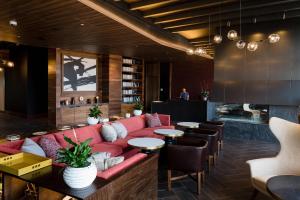 a lobby with a red couch and tables and chairs at Cambria Hotel Boston Somerville in Somerville +84 photos