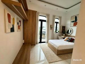 a bedroom with a bed and some paintings on the wall at Sunrak House in Ðạo Thành
