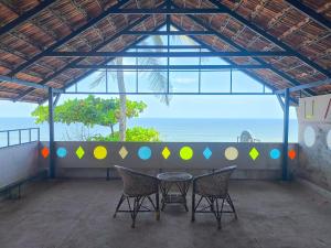 a table and chairs in a room with a view of the ocean at Tiny Temple in Varkala