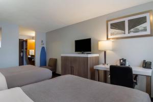 a hotel room with two beds and a flat screen tv at Quality Inn & Suites Silverdale Bangor-Keyport in Silverdale