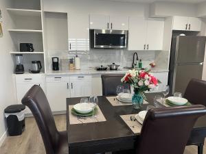 a kitchen with a dining table with chairs and a refrigerator at Lakeview 2Bedroom Walkout Suite with Trail View in Winnipeg