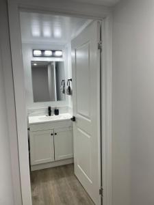 a white bathroom with a sink and a mirror at Lakeview 2Bedroom Walkout Suite with Trail View in Winnipeg