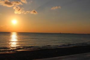 un tramonto sulla spiaggia con una nave in acqua di Triathlon B&B a Lecce
