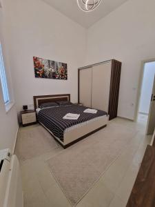 a bedroom with a bed and a painting on the wall at Elena Apartments in Absolute Center in Ruse