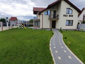 ein Haus mit einem Gehweg vor dem Garten in der Unterkunft Vila MEM in Sebeş