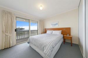 a bedroom with a bed and a large window at Tahren Beach Getaway in Middleton
