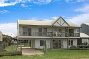 a large white house with a porch and balcony at Tahren Beach Getaway in Middleton