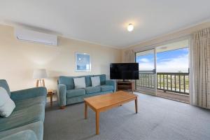 a living room with a couch and a tv at Tahren Beach Getaway in Middleton