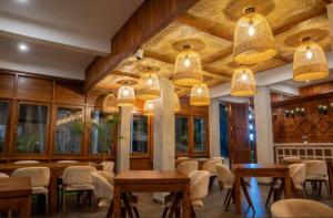 a restaurant with wooden tables and chairs and lights at Crystal springs mount face Hotel in Ella
