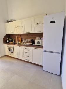 a kitchen with white cabinets and a white refrigerator at Elena Apartments in Absolute Center in Ruse