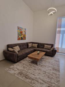 a living room with a brown couch and a coffee table at Elena Apartments in Absolute Center in Ruse